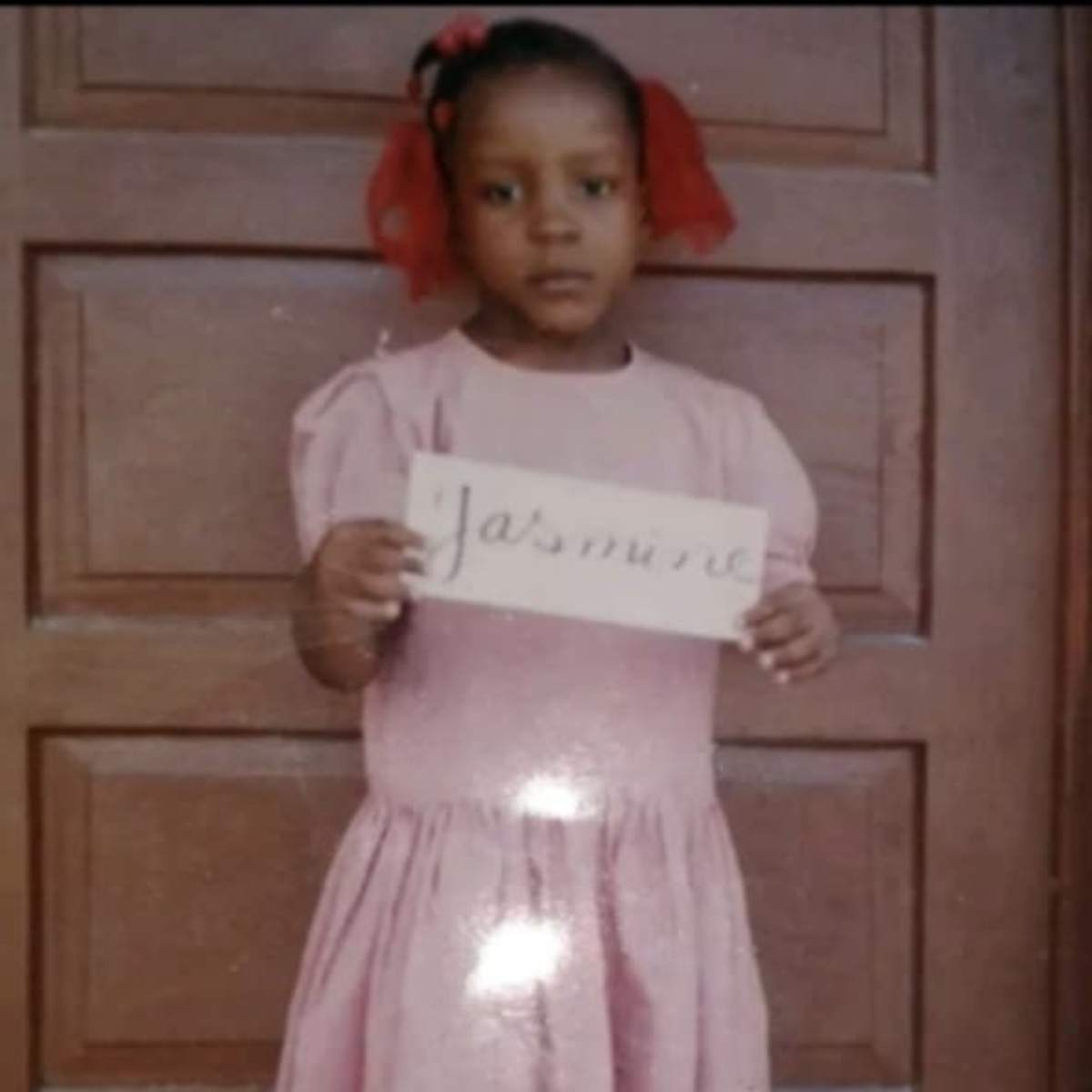 Young Jasmine holding a name sign