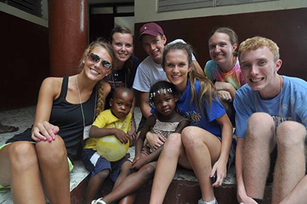 Group of smiling visitors and kids.